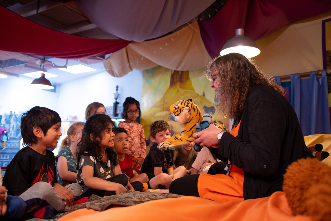 Children listening to a story on the big bed in Small Worlds