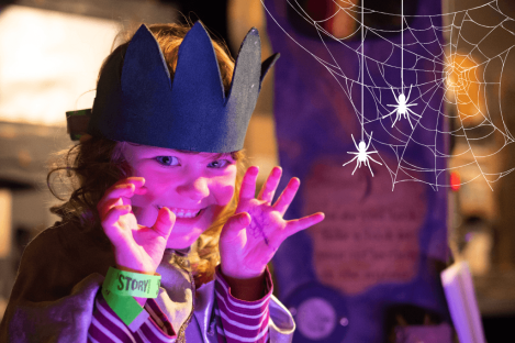 Girl making spooky face with spiders webs